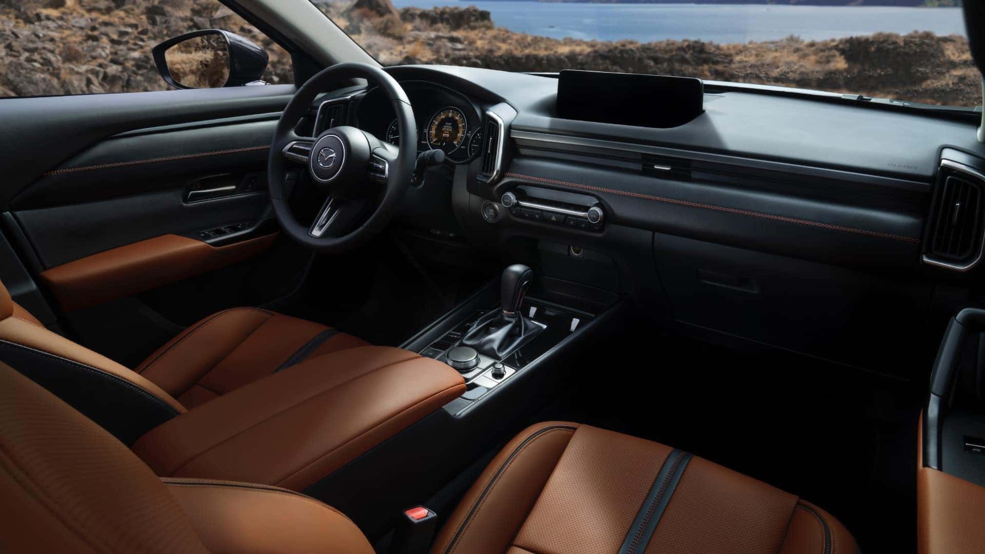 Brown leather front seats and contrast stitching inside the 2026 Mazda CX-50 Hybrid