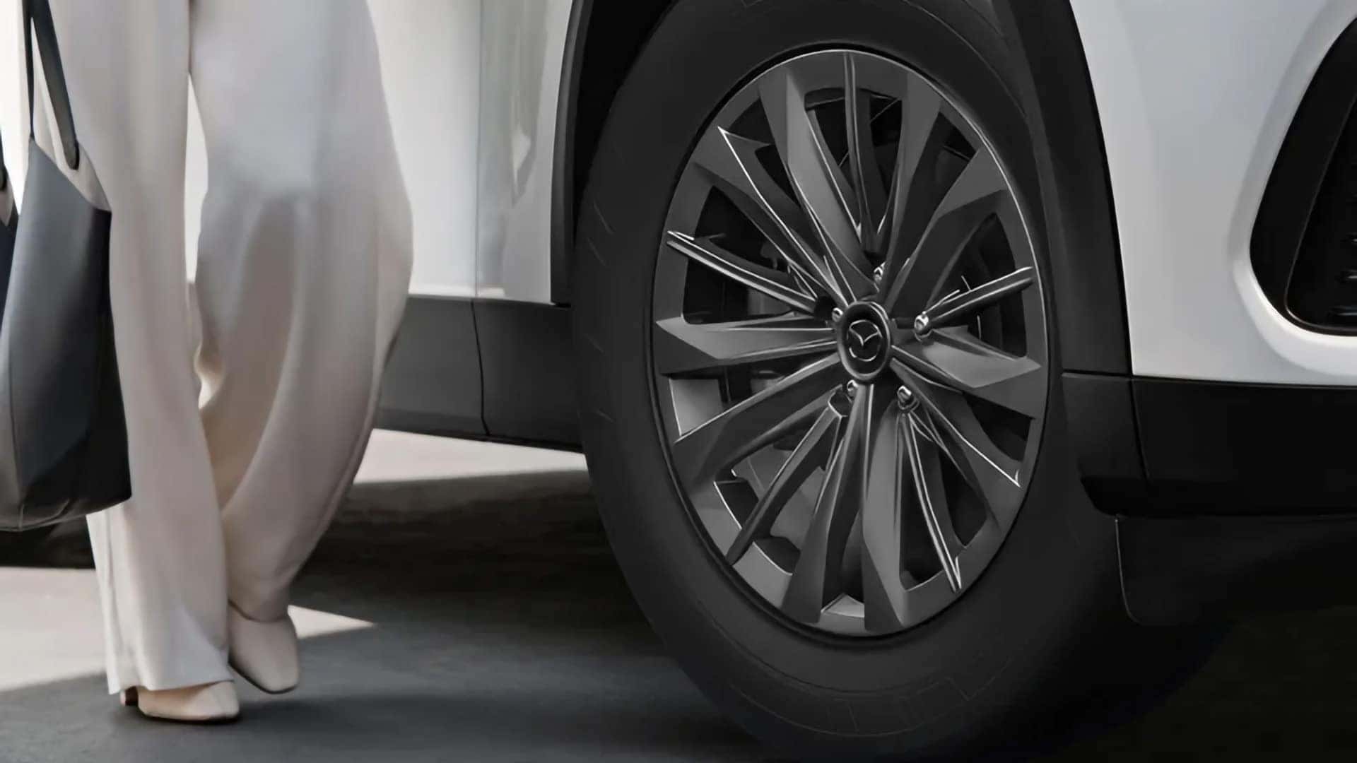 Close-up of a Gray Metallic aluminum alloy wheel on a white 2026 Mazda CX-70 PHEV