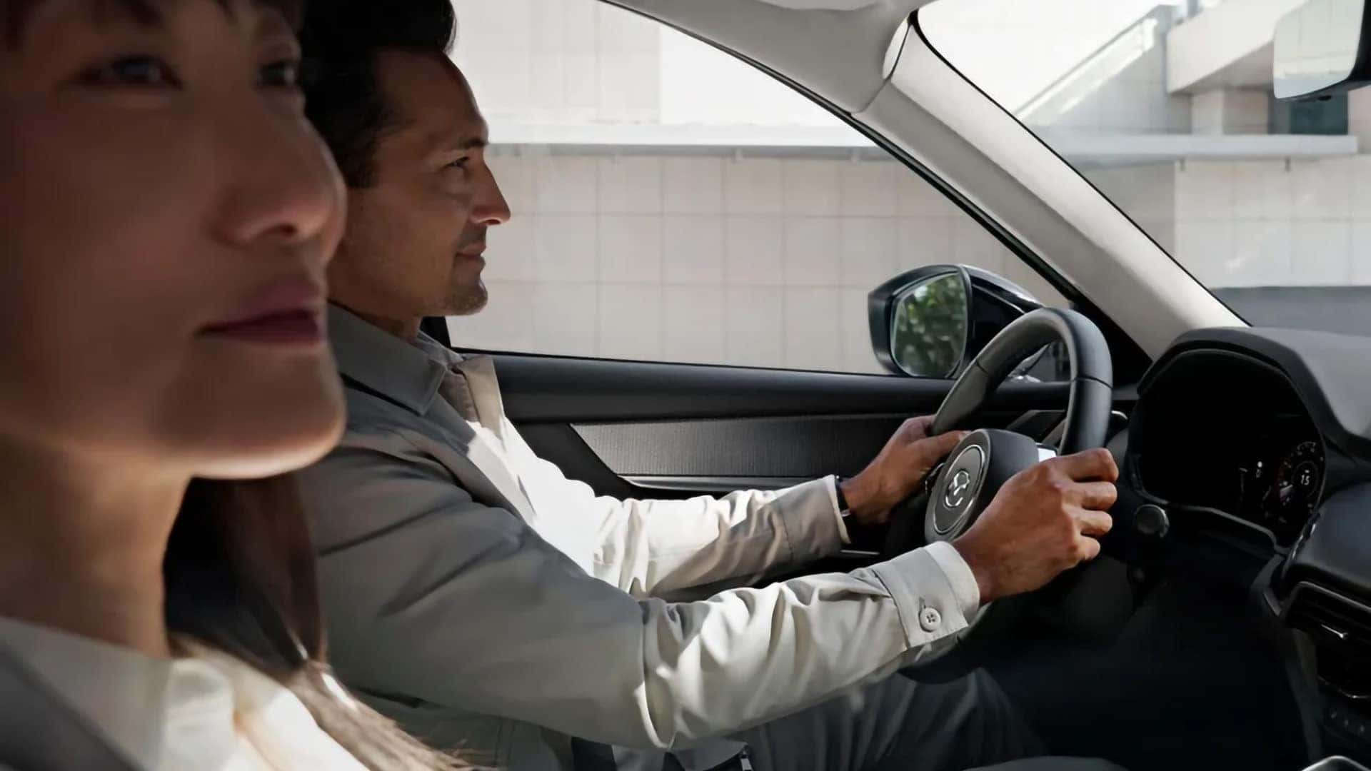 Driver and front passenger using the connected cabin vehicle environment inside a 2026 Mazda CX-70 PHEV