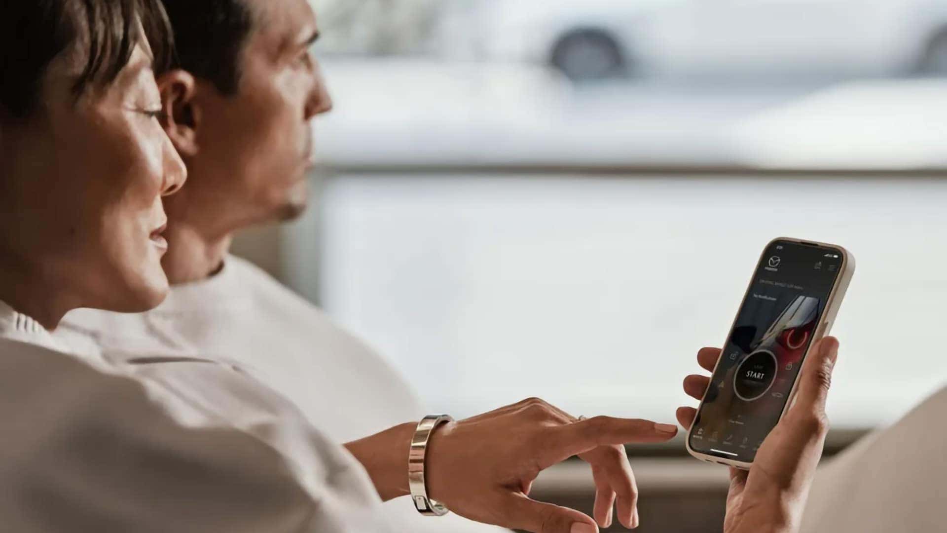 Driver using the MyMazda App to access remote features for a Mazda vehicle