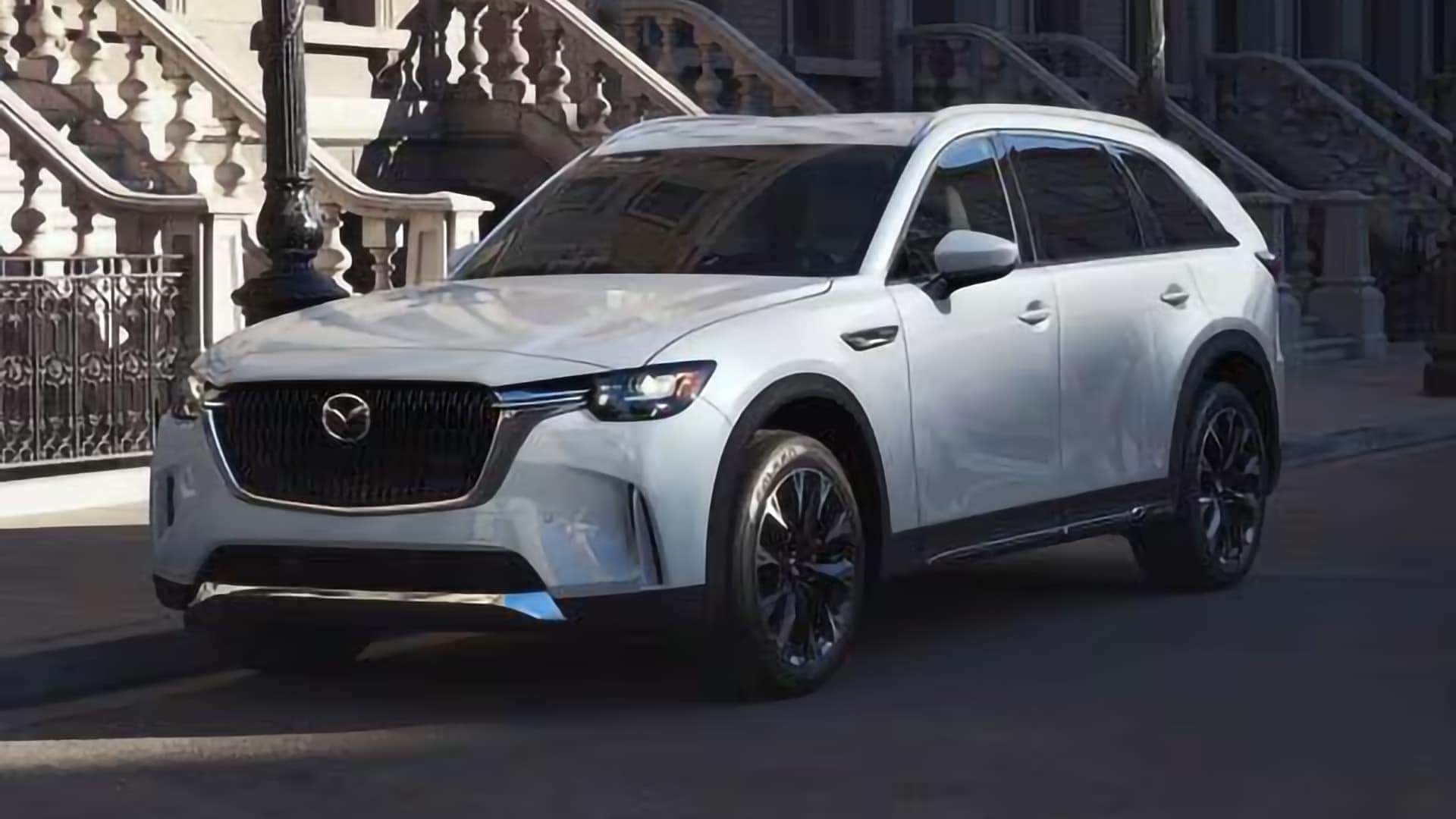 White 2026 Mazda CX-90 PHEV in front three-quarter view showing its large alloy wheels