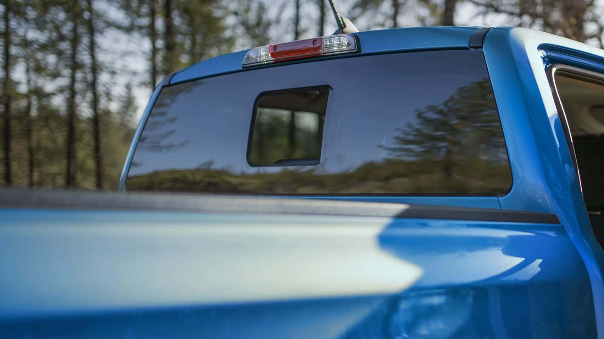 Close-up of a blue 2026 Ford Ranger rear cab, pickup bed, and high-mounted brake light