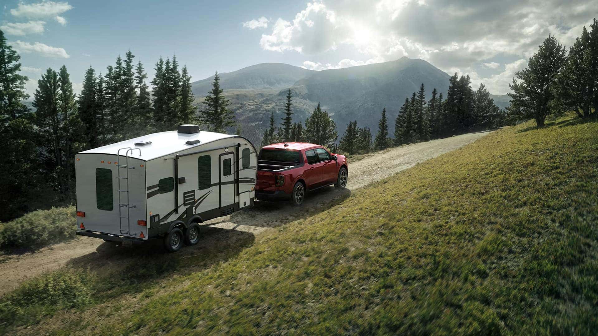 Red 2026 Ford Maverick towing a travel trailer along a mountain road