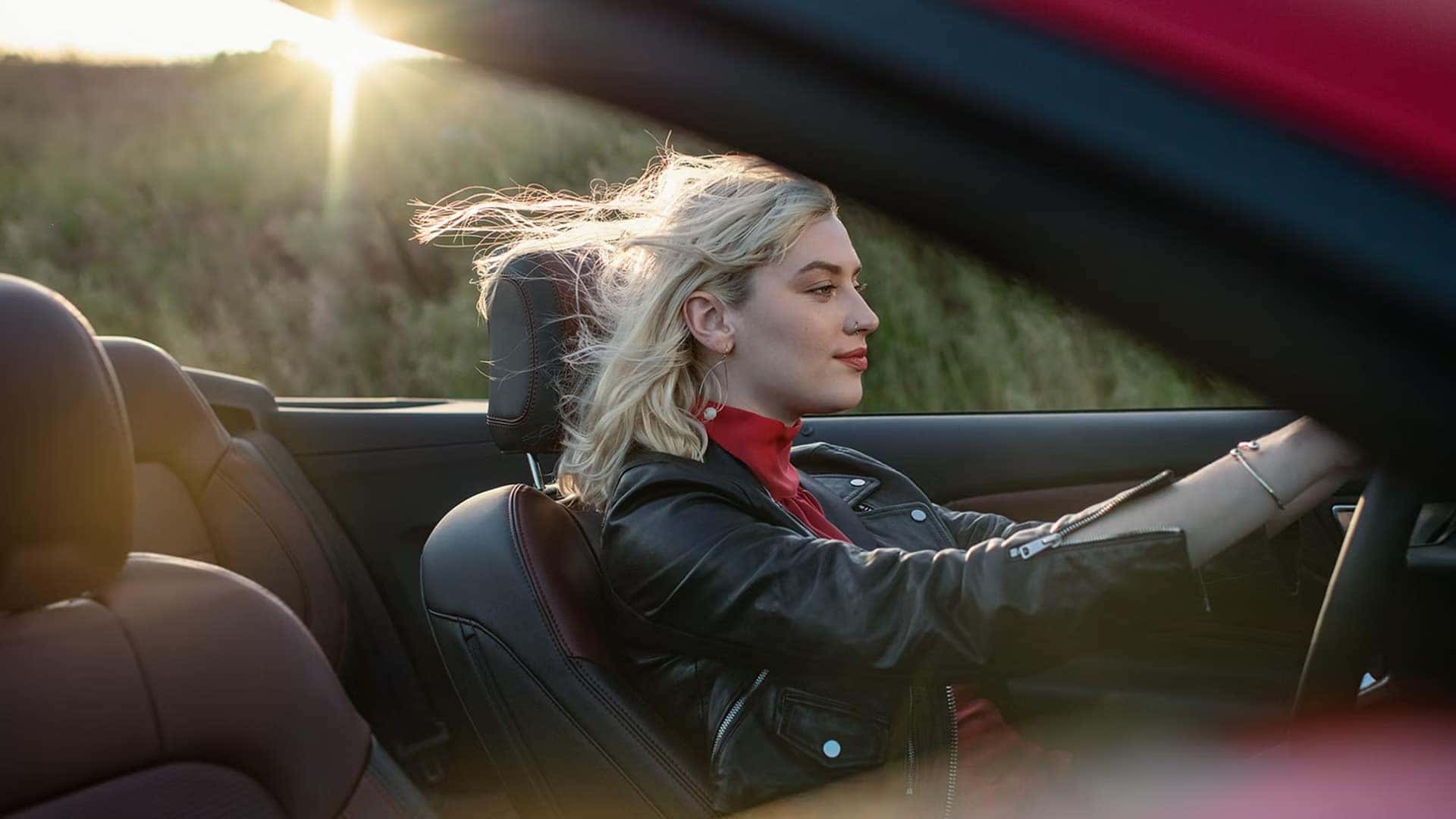 Driver in a 2026 Ford Mustang convertible with the roof lowered during an open-air drive