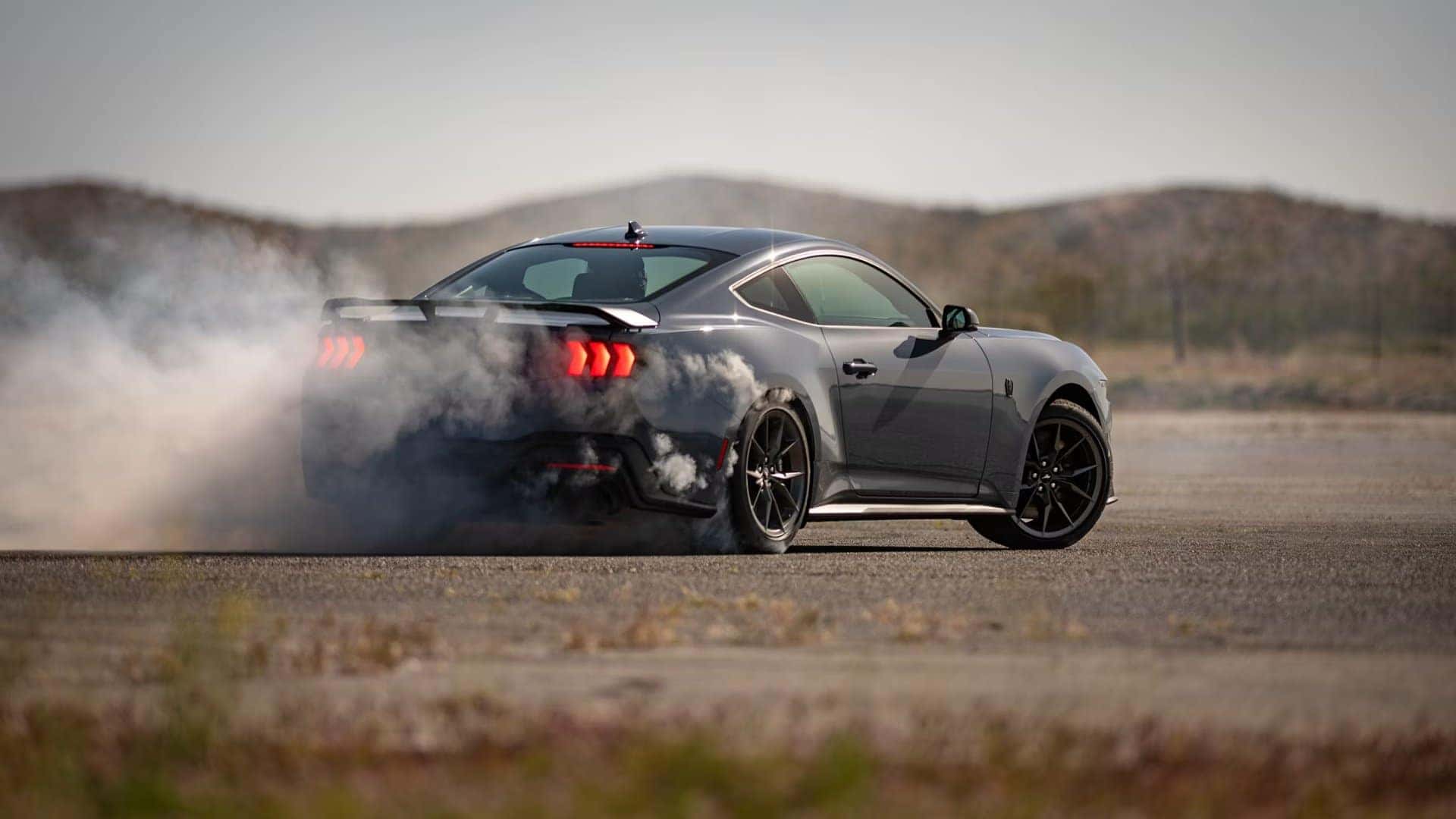 Gray 2026 Ford Mustang performing a controlled drift on a closed driving course