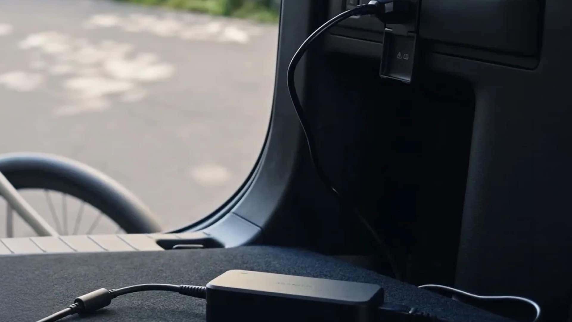 Power outlet charging a compatible device inside the 2026 Mazda CX-90 PHEV