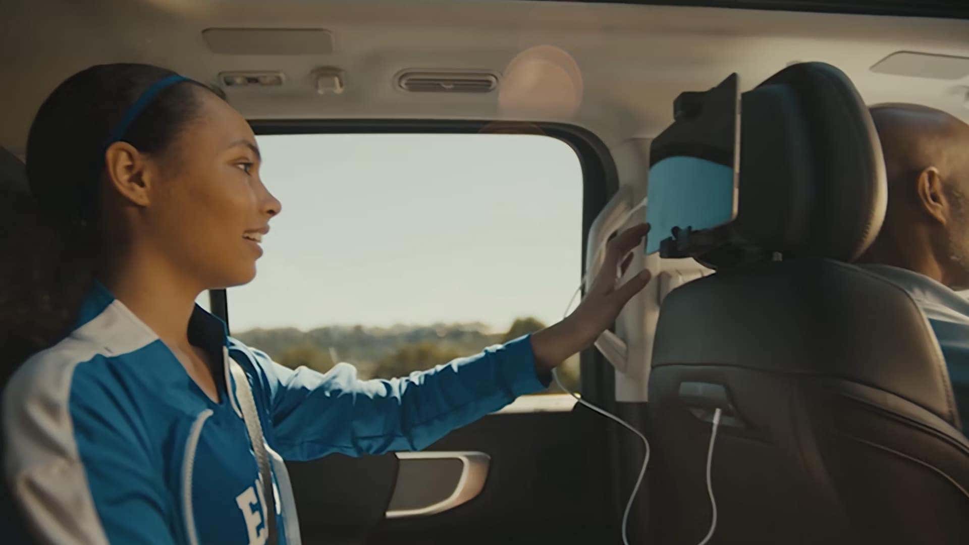 Rear passenger using a tablet mounted behind the front seat in a 2026 Ford Expedition