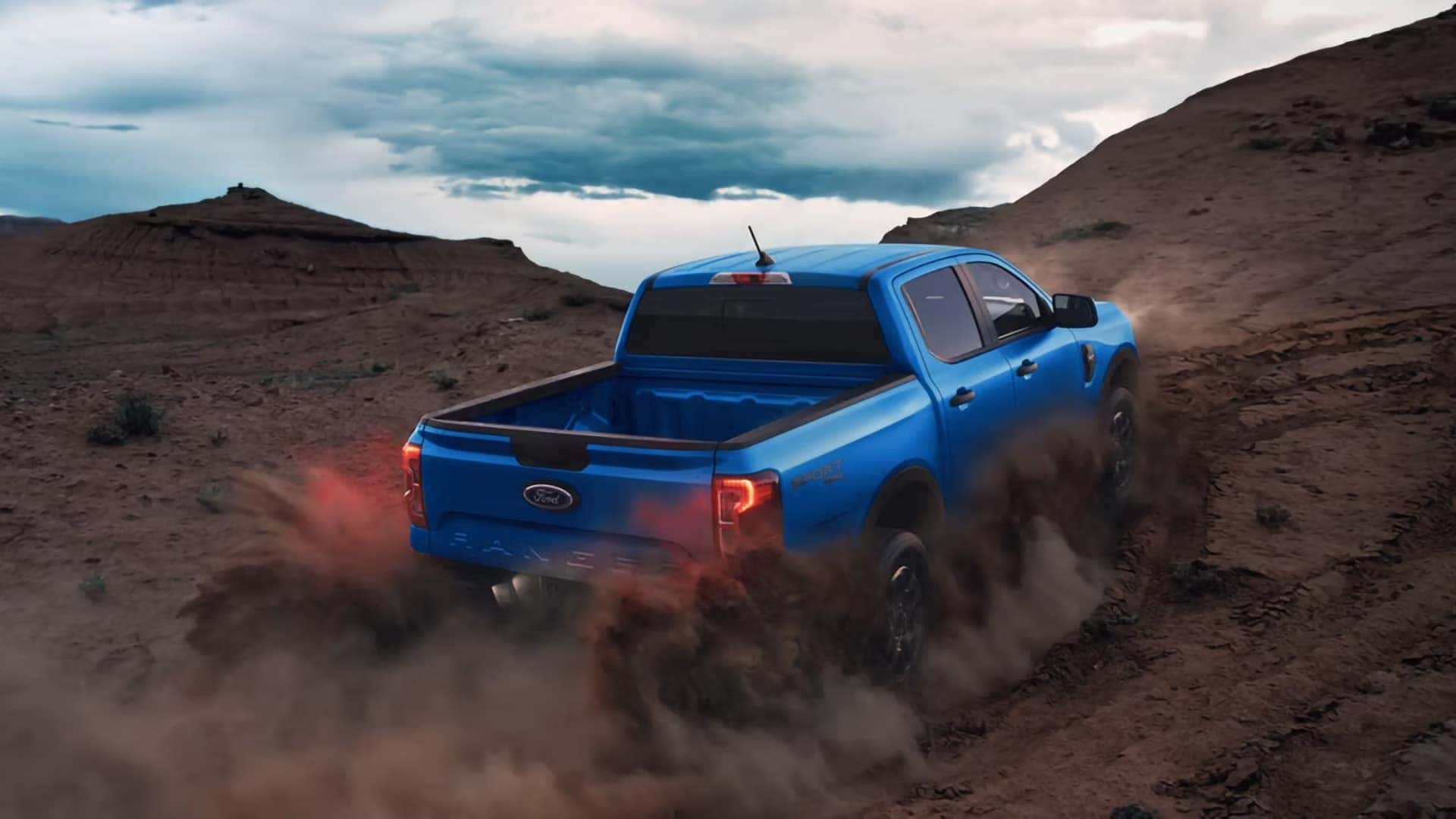 Blue 2026 Ford Ranger 4x4 climbing a rugged dirt trail