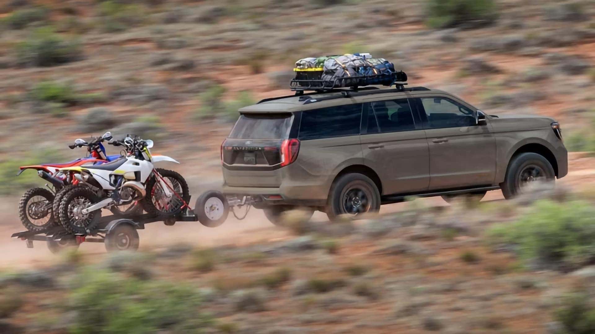 2026 Ford Expedition towing a trailer with dirt bikes on an off-road trail