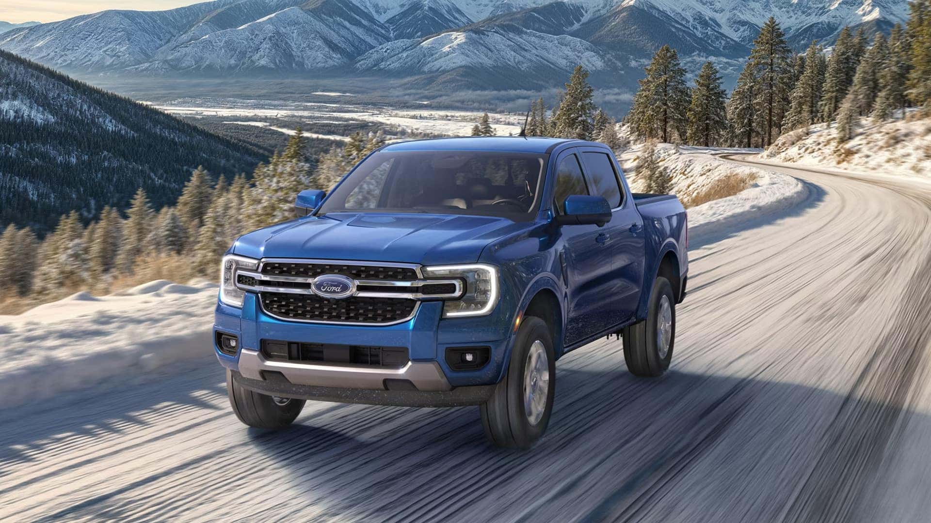 Blue 2026 Ford Ranger driving on a snow-covered mountain road