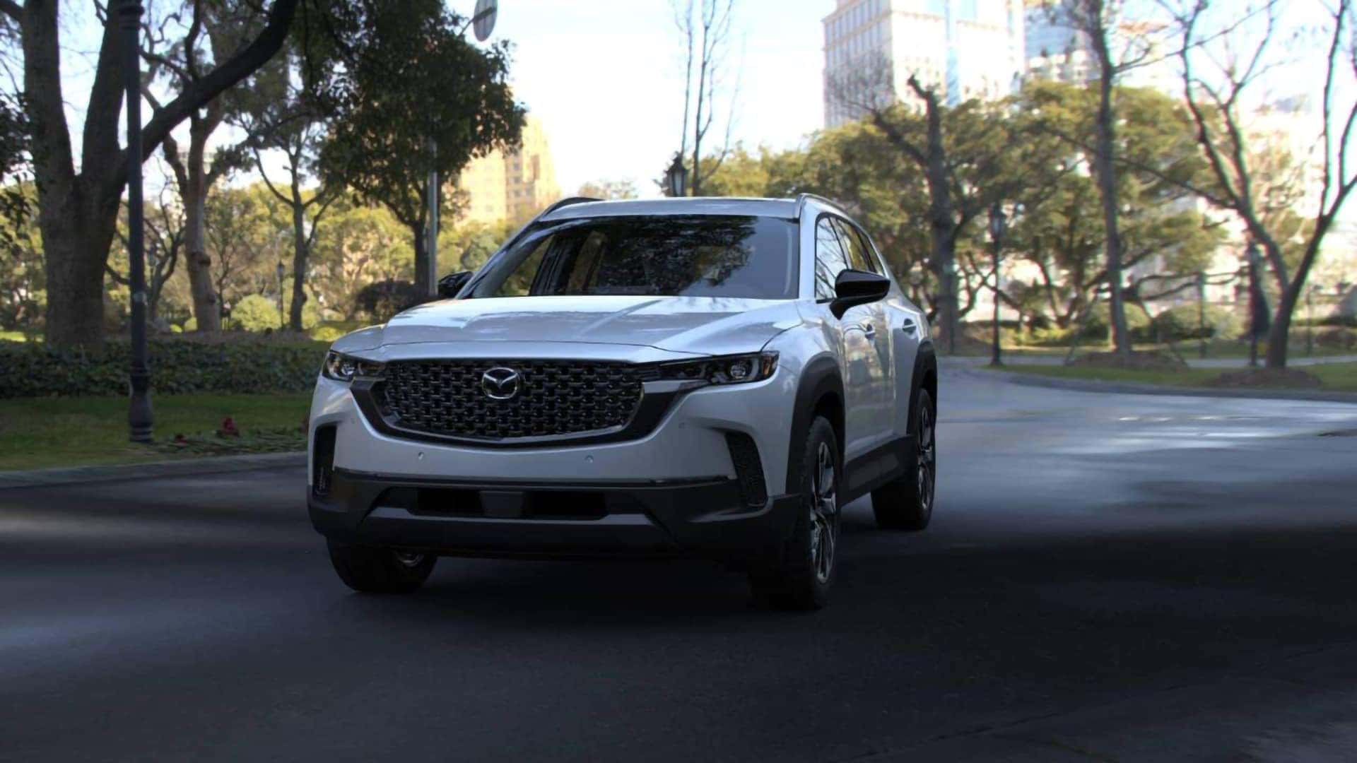 White 2026 Mazda CX-50 Hybrid shown from the front three-quarter angle on a city street