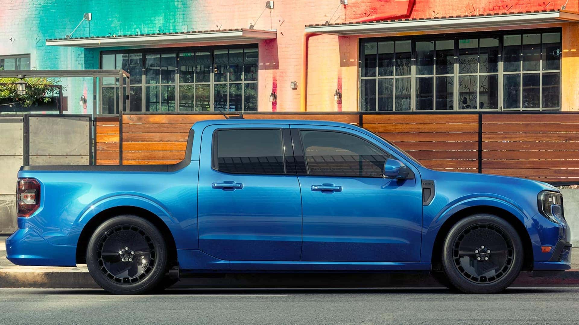 Side view of a blue 2026 Ford Maverick Lobo parked outside a building