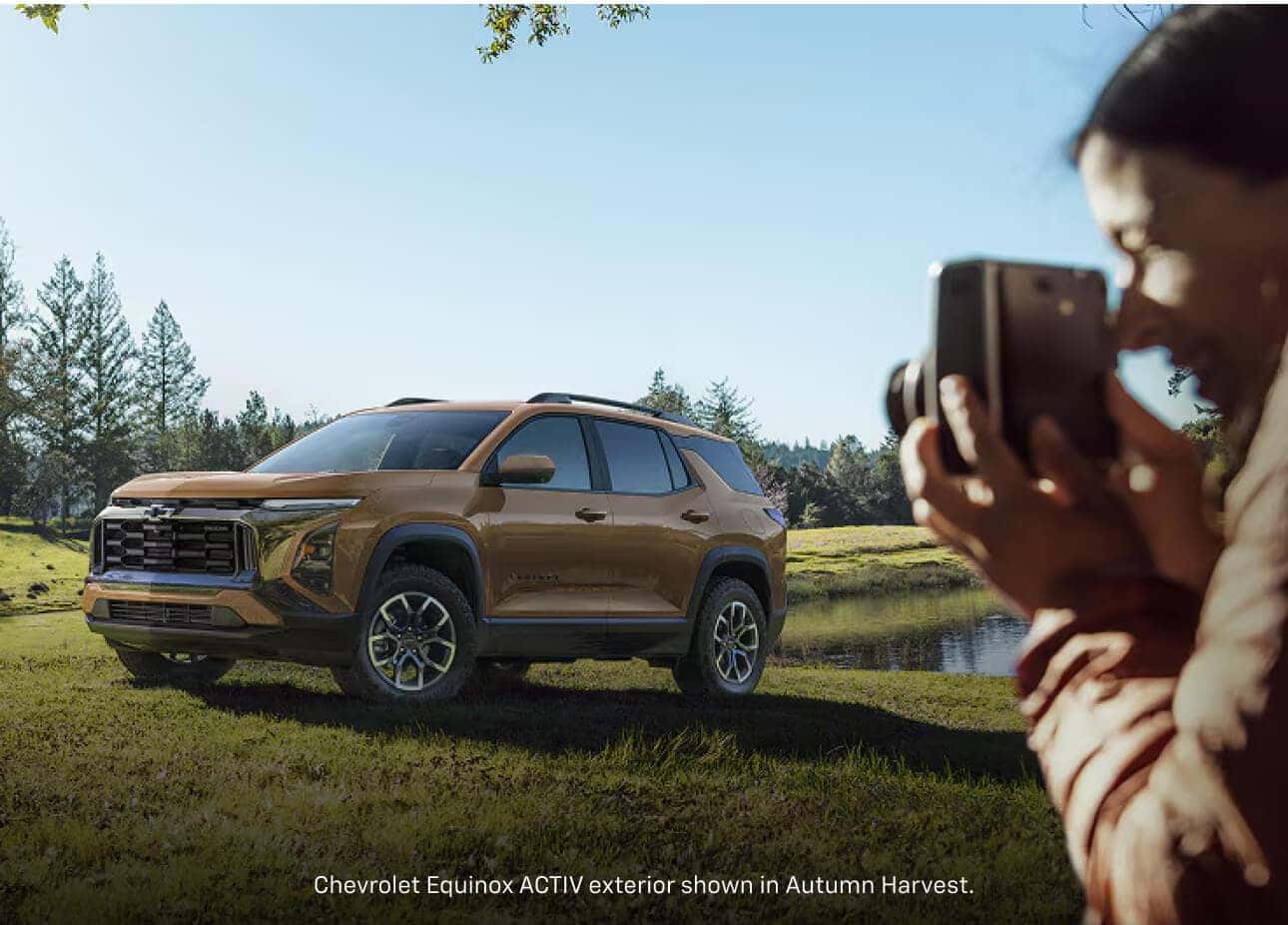 Front three-quarter view of a 2026 Chevrolet Equinox ACTIV in Cacti Green being photographed near a lake.